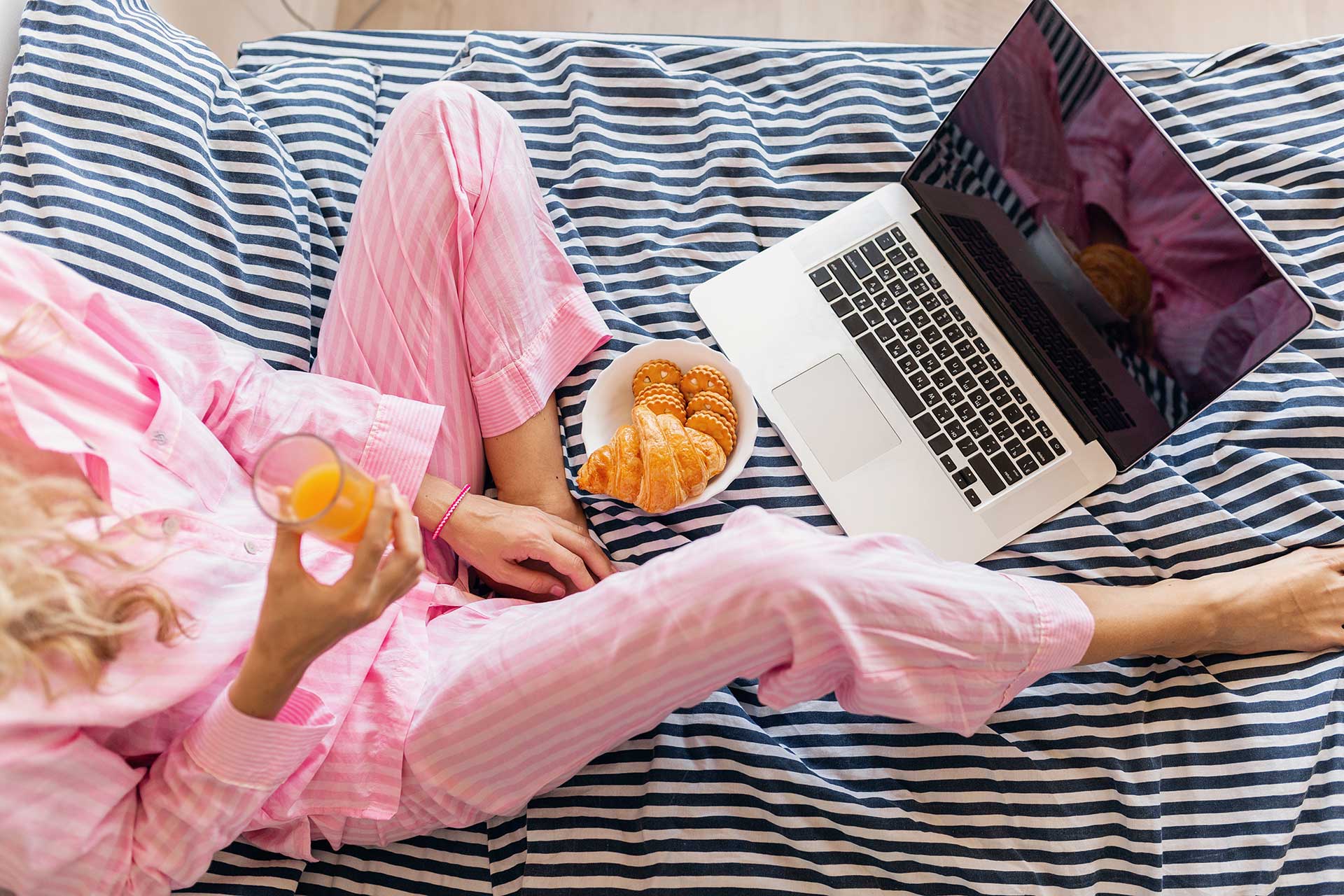 Женщина в пижаме сидит на кровати